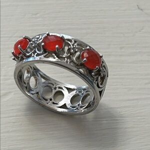 silver tone ring with three oval coral colored stones in ornate southwest design